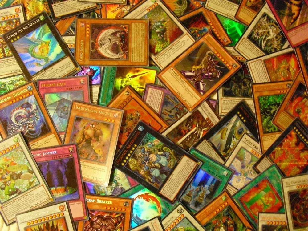 A large collection of Yu-gi-oh cards spread across the photo.